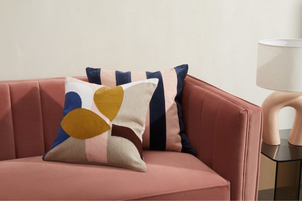 Wohnzimmer modernisieren: Dekorative Kissen aufs Sofa legen